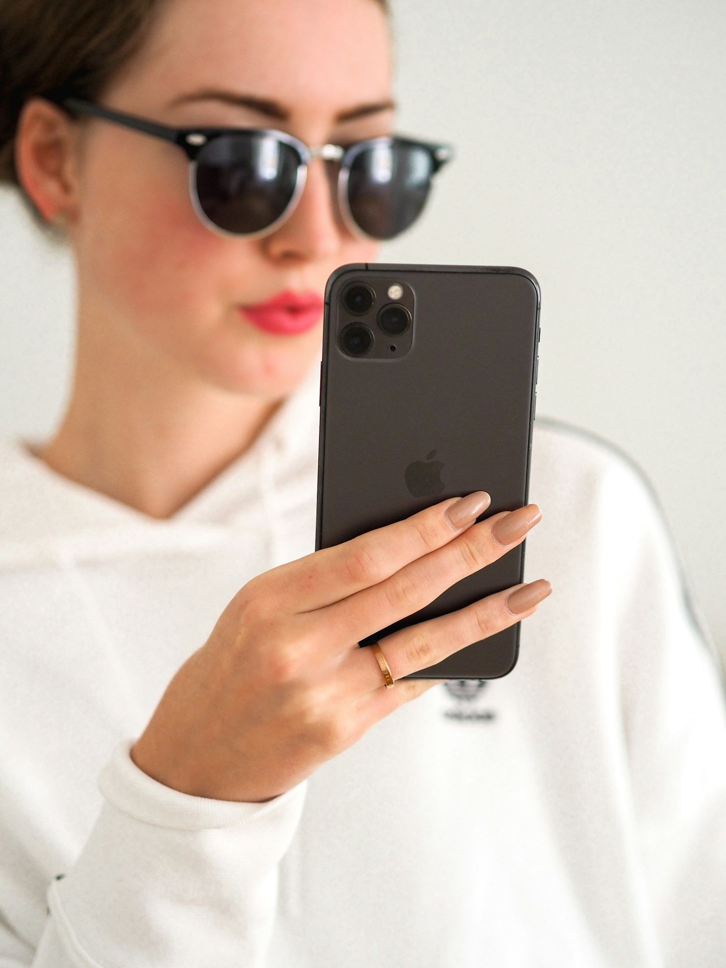 man in white shirt holding black iphone 7 plus